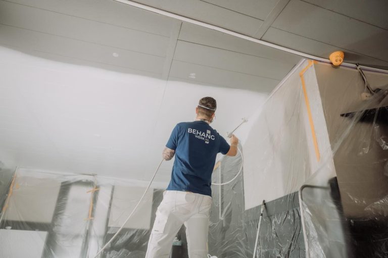 Schilder spuit het plafond van een woning