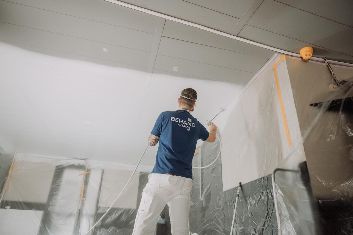 Schilder spuit het plafond van een woning