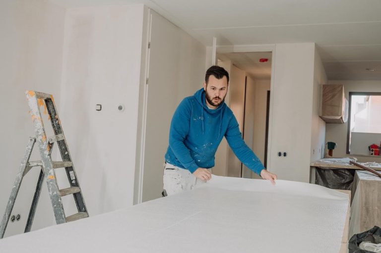 Behanger controleert het snijgedeelte van het behang