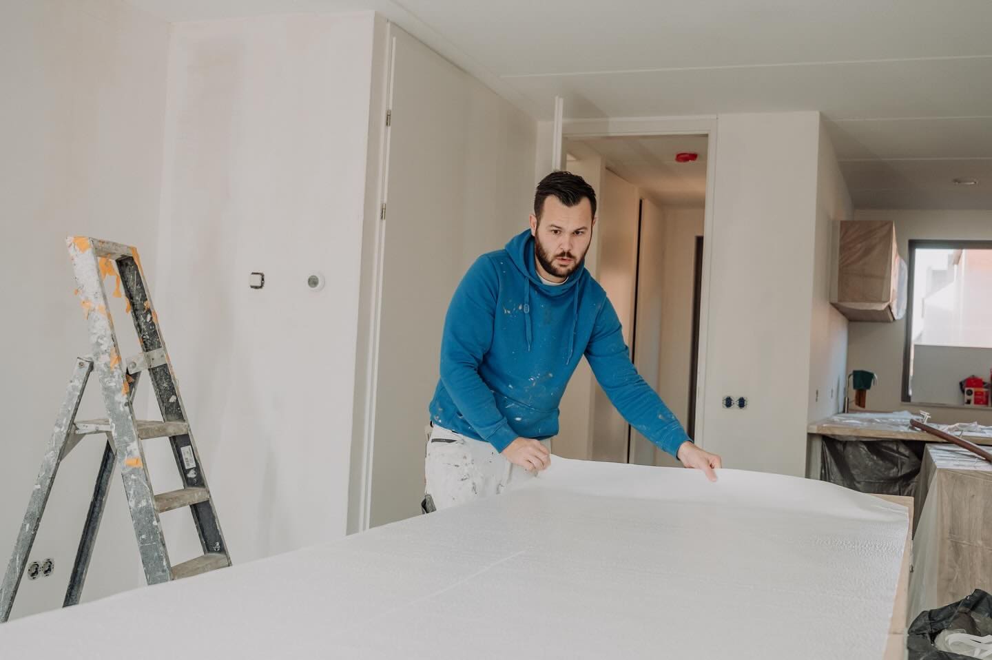 Behanger controleert het snijgedeelte van het behang
