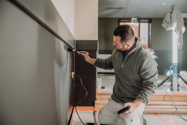 Schilder werkt de randen af van een wand