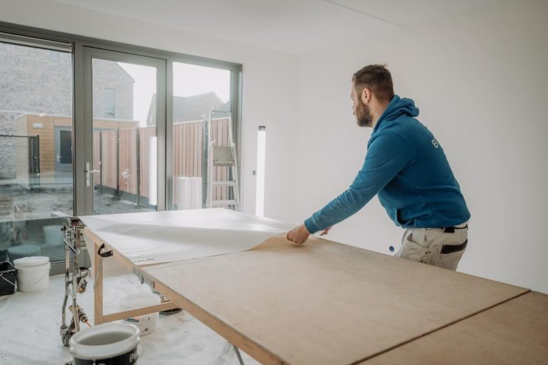 Behanger snijdt een stuk behang